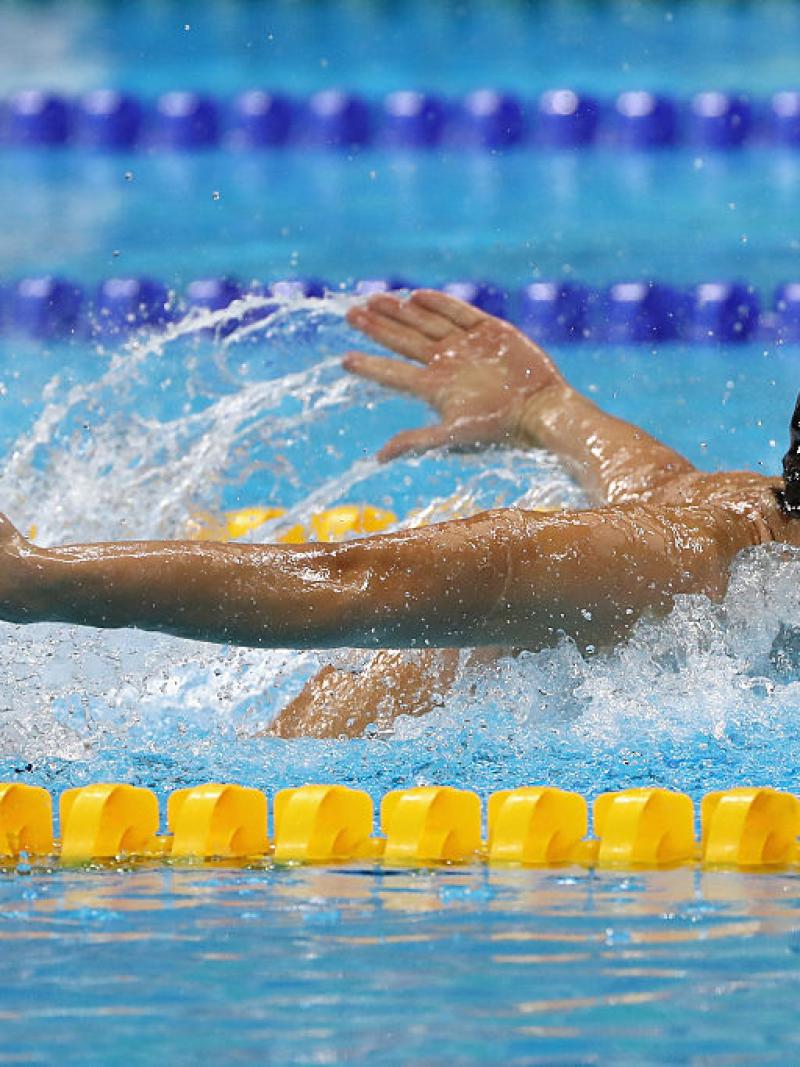 Male swimmer in water competing in butterfly stroke