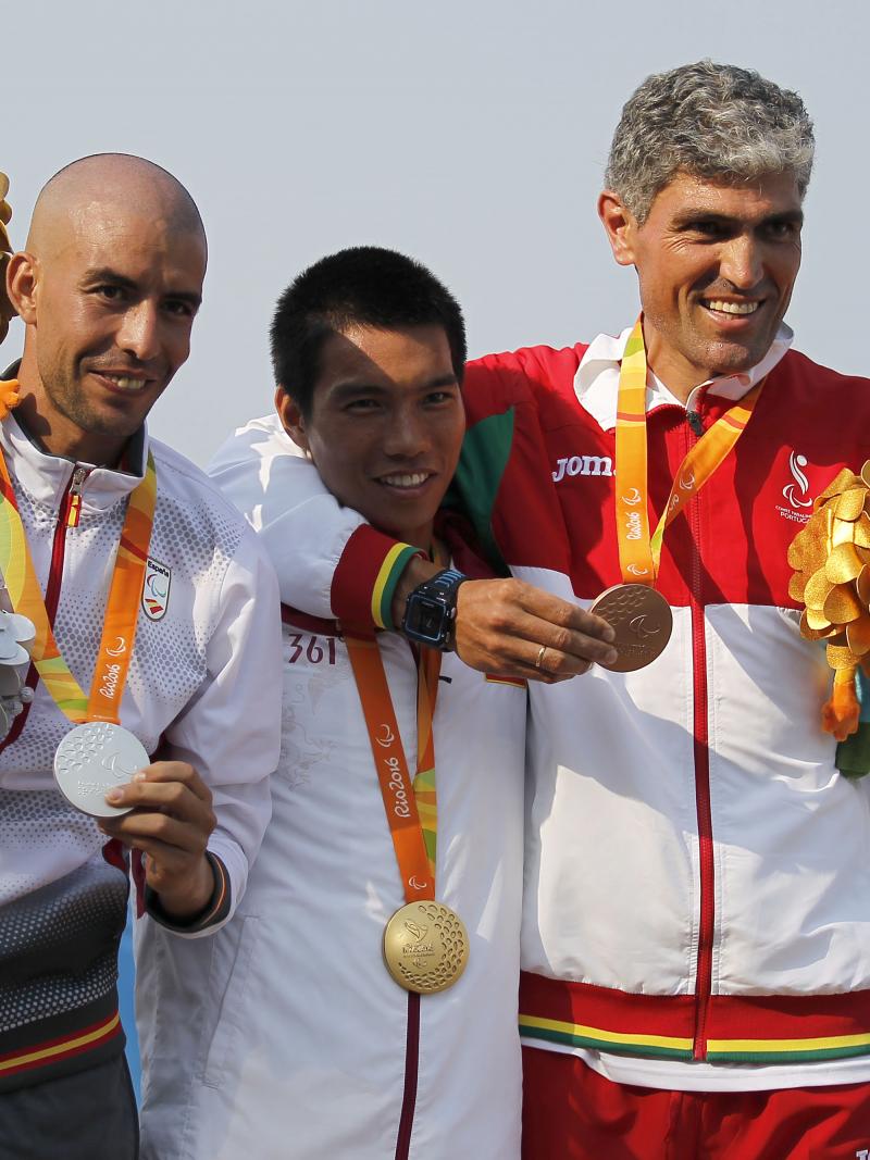 Three men on the podium, smiling