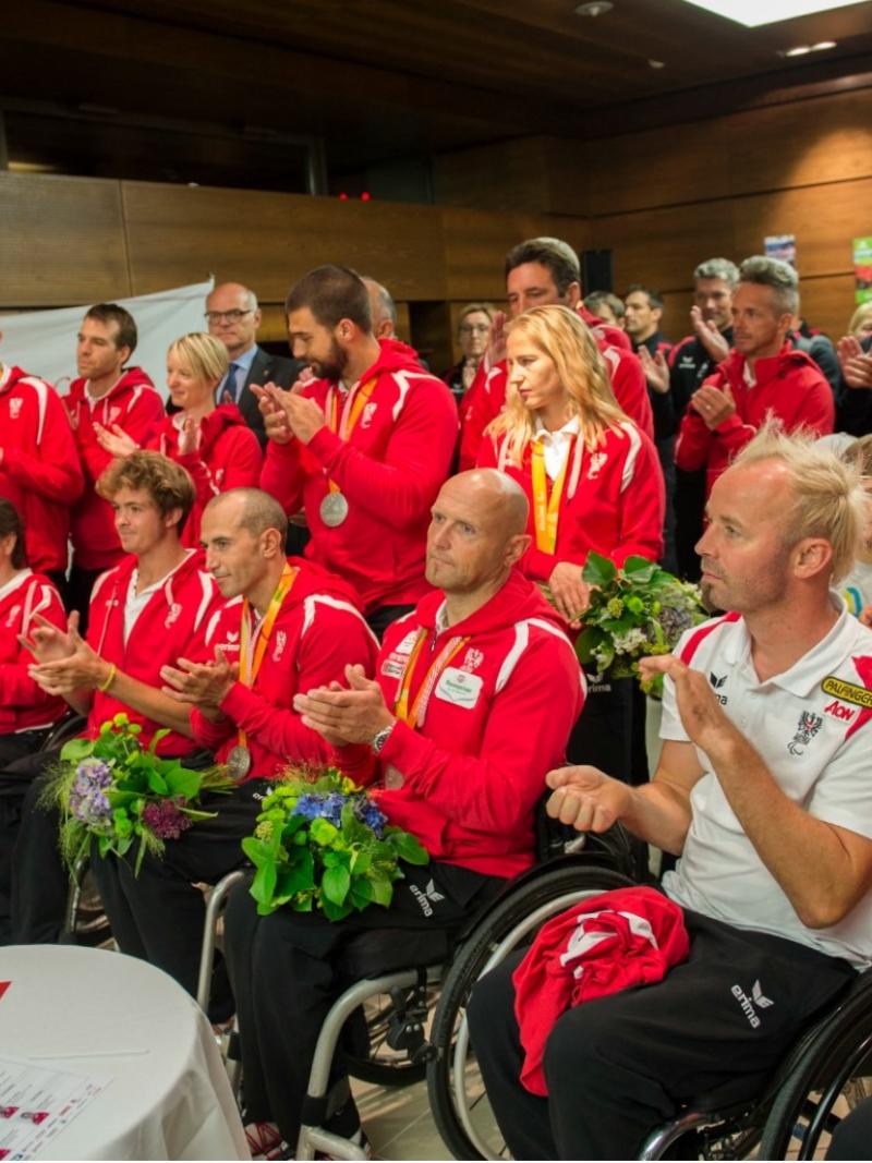 A group of athletes is welcomed by sports dignitaries