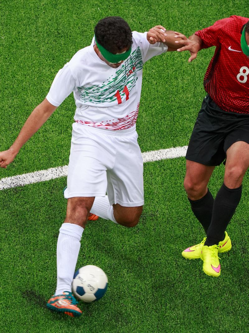 Two blind footballers fighting for the ball