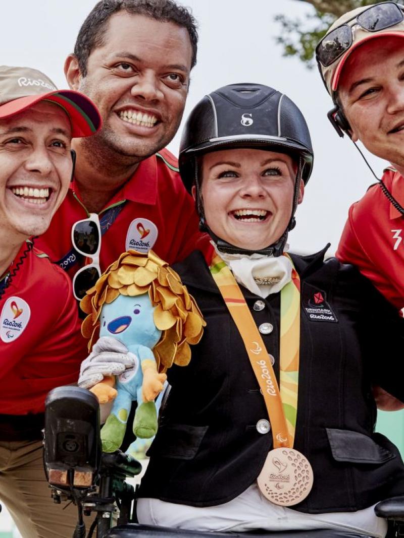 Stinna Tange Kaastrup celebrating her gold medal with volunteers.