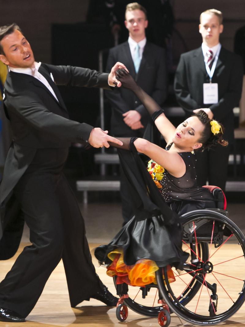 A woman in wheelchair dances with a man standing up