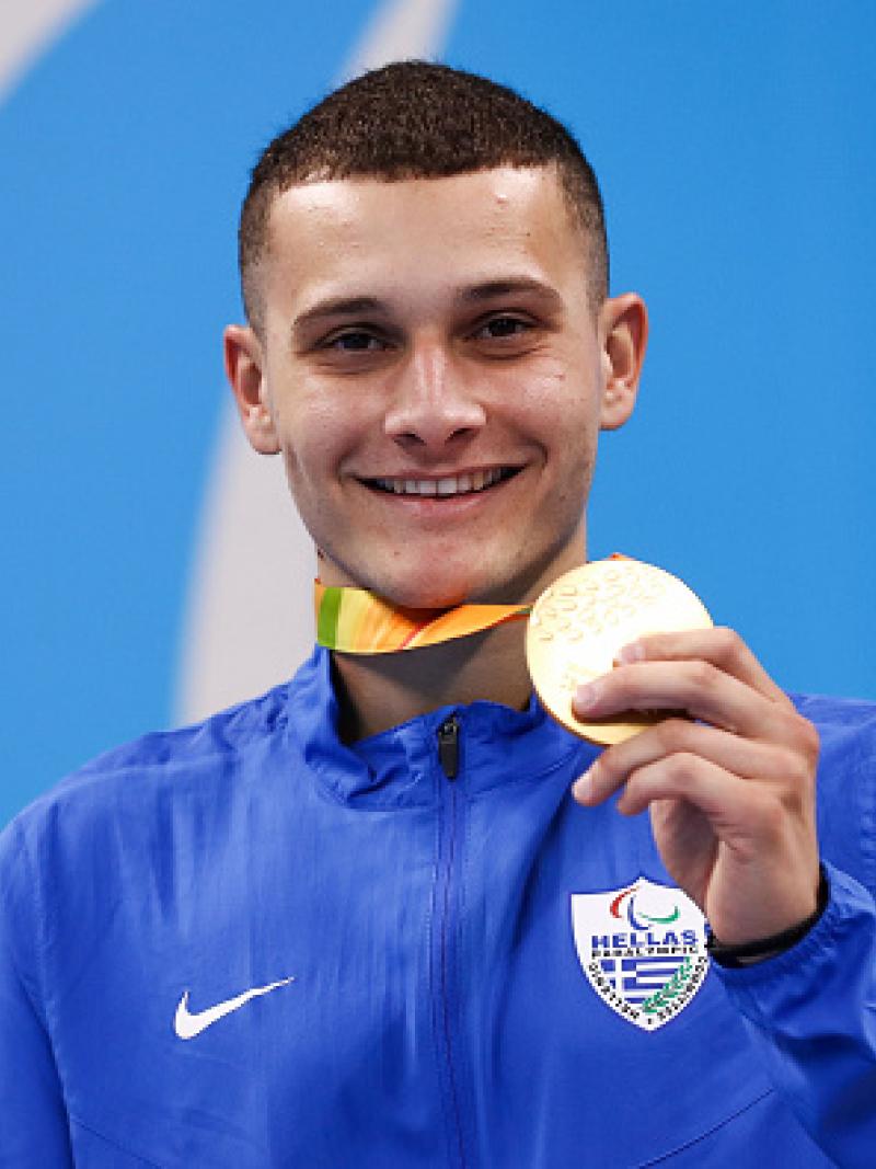 Man on podium showing his medal