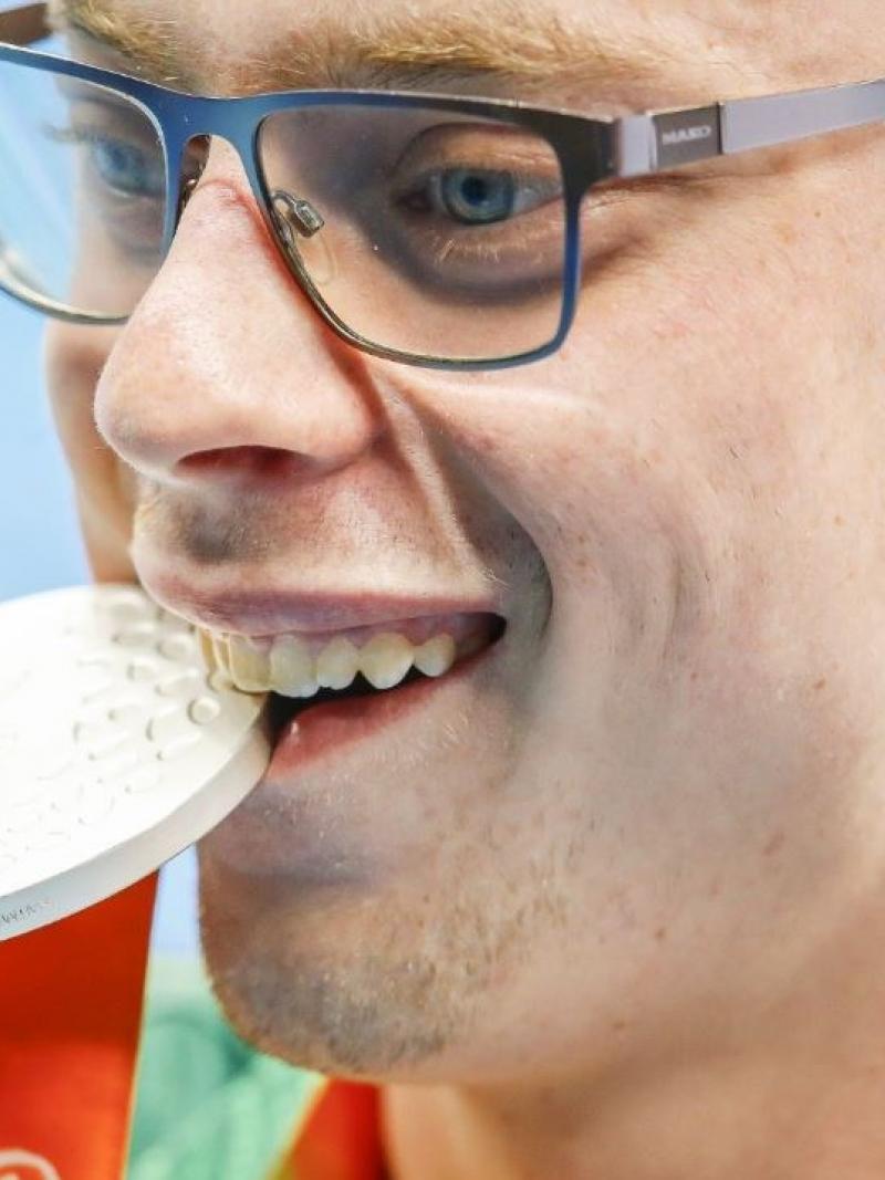 Face of a man biting on a medal
