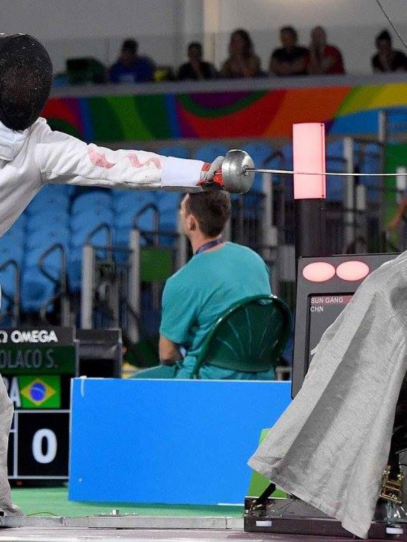 Two men in wheelchairs fencing