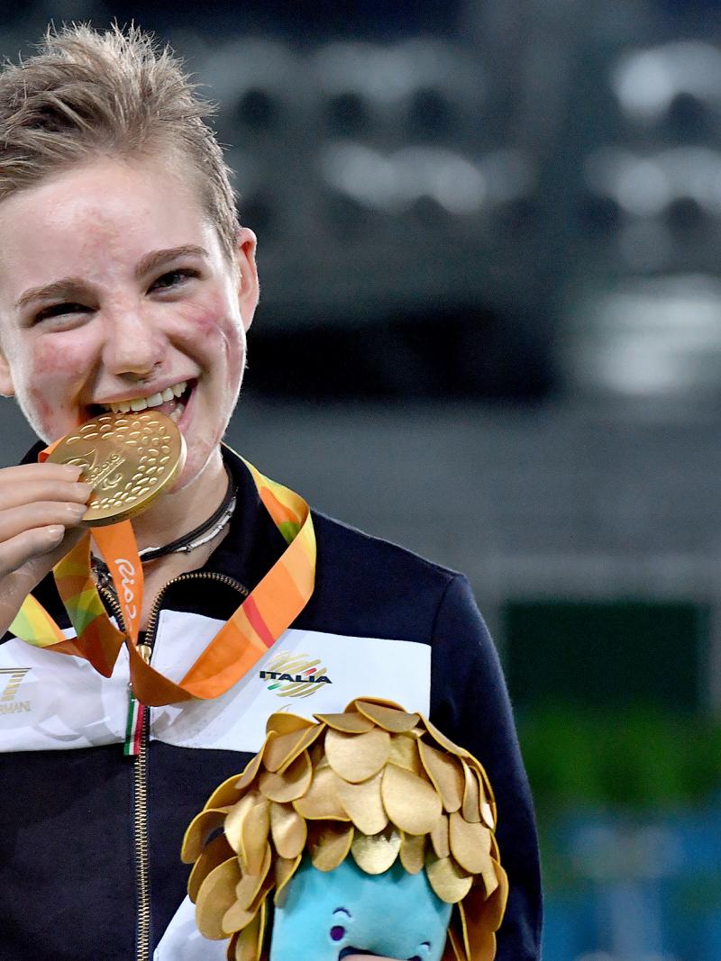 Young woman shows a medal and smiles