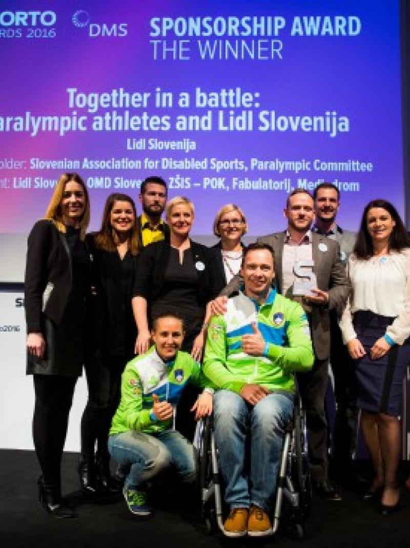 Group of people pose for picture on stage