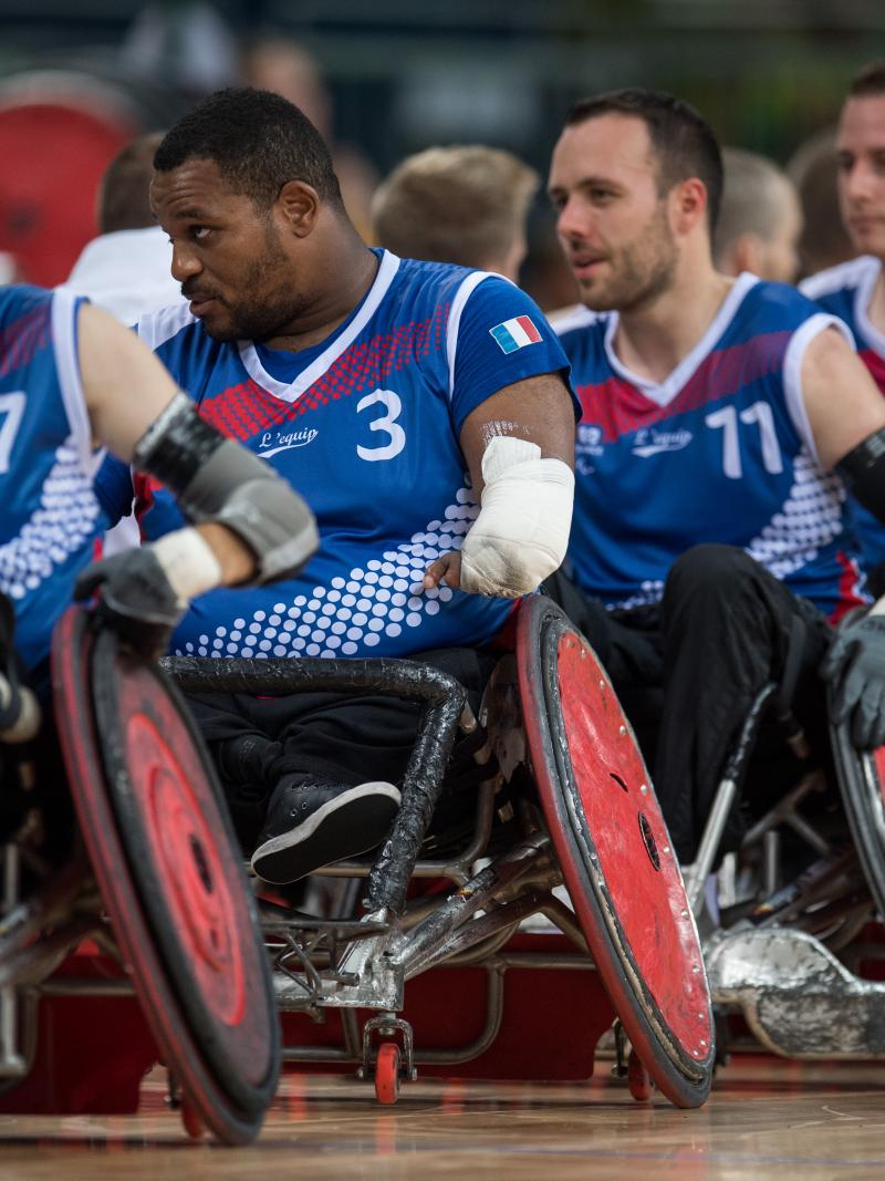 Men in wheelchairs form a line