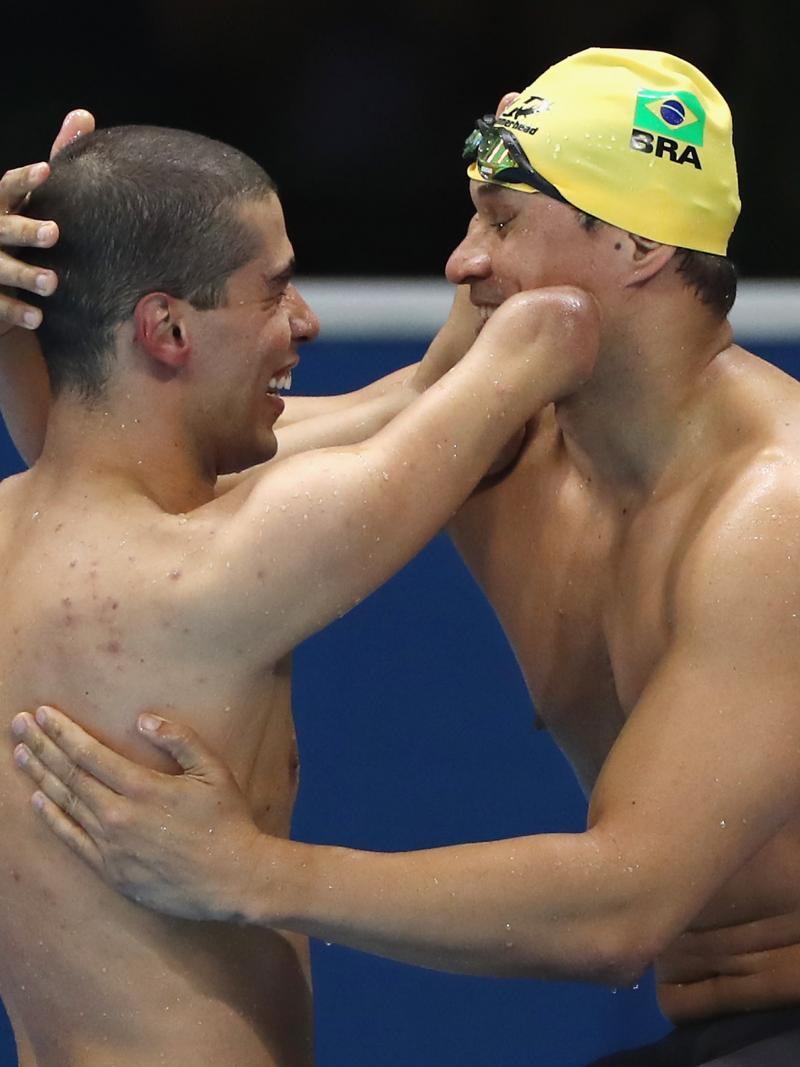Two Para swimmers embrace after a race