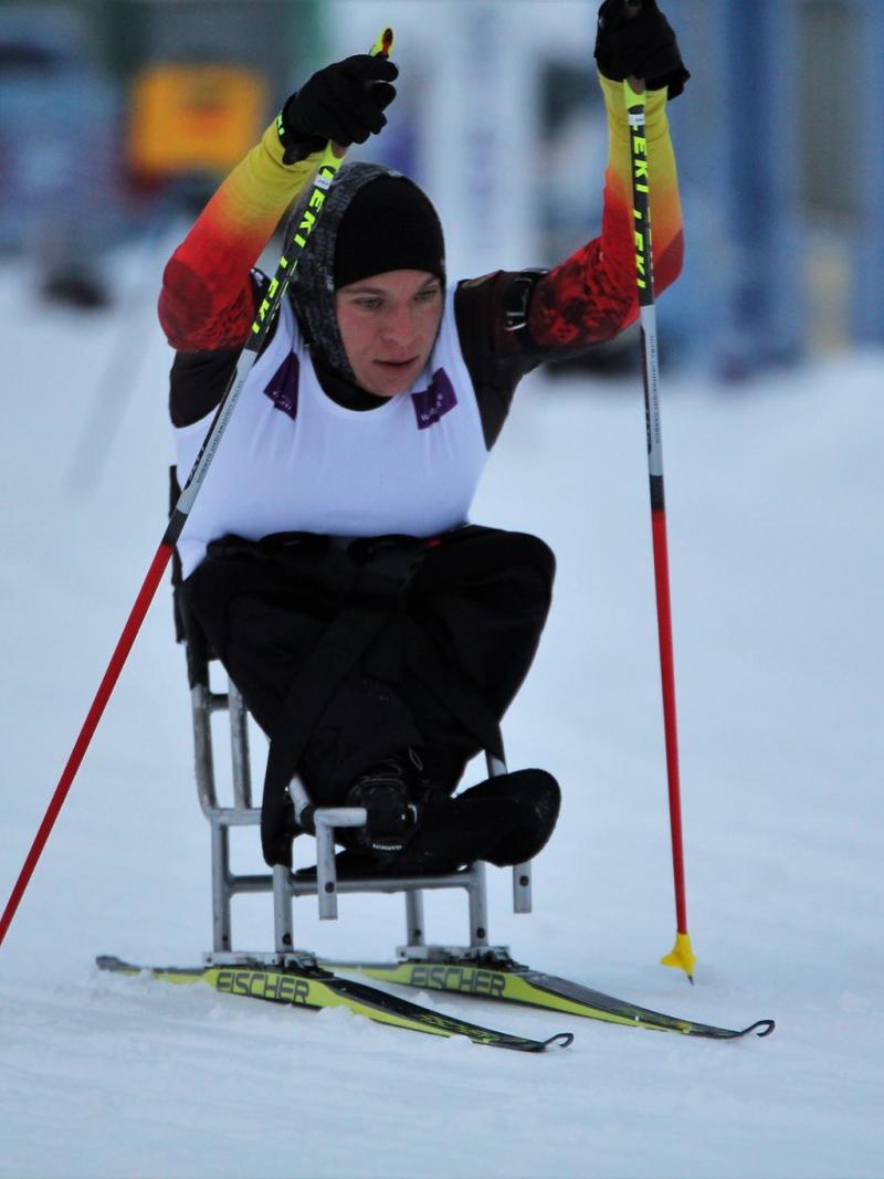 Woman with no legs in sit ski on a slope