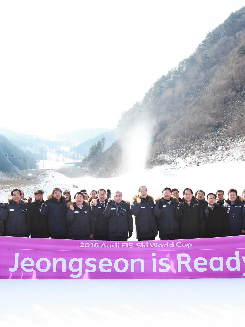 Group of people pose in front of slopes