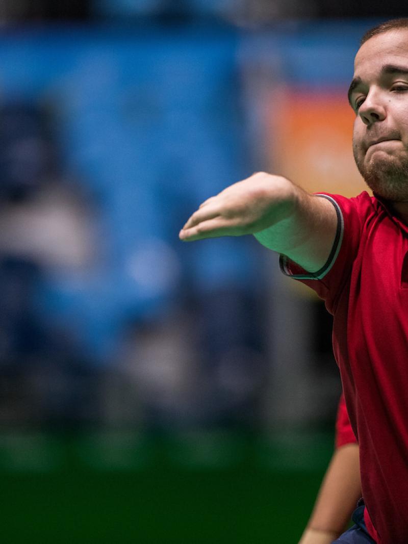 Upper body of man throwing a red ball