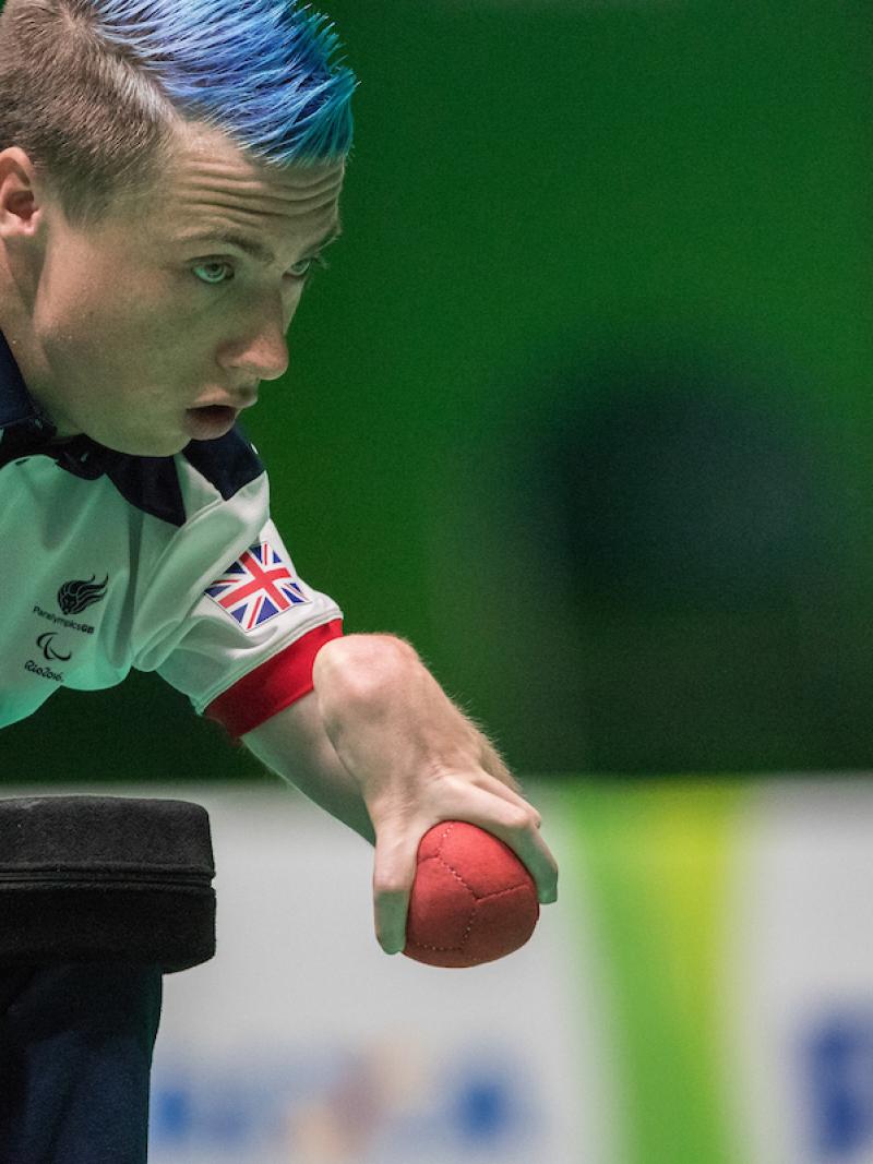 a male boccia player prepares to throw the ball