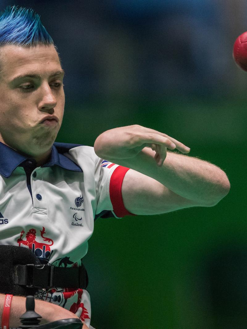 Upper body of man throwing a red ball