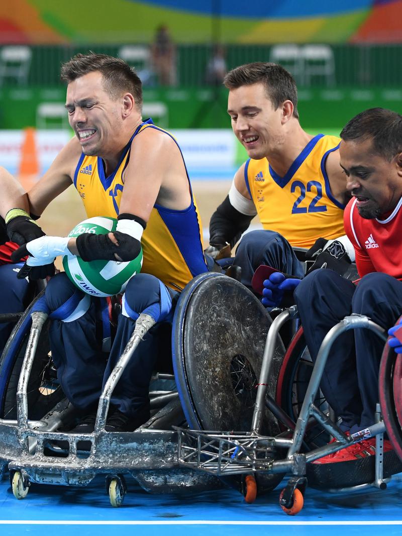 Four wheelchair rugby players fighting for the ball.