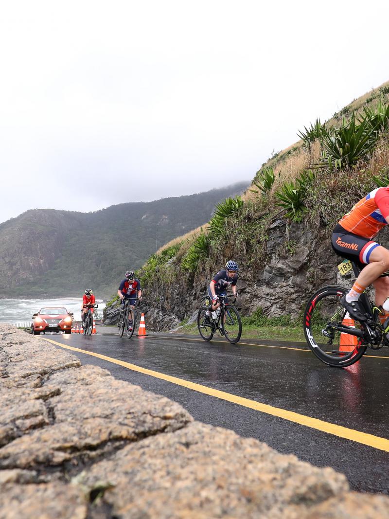 A group of cyclists climbing up a hill in a road race