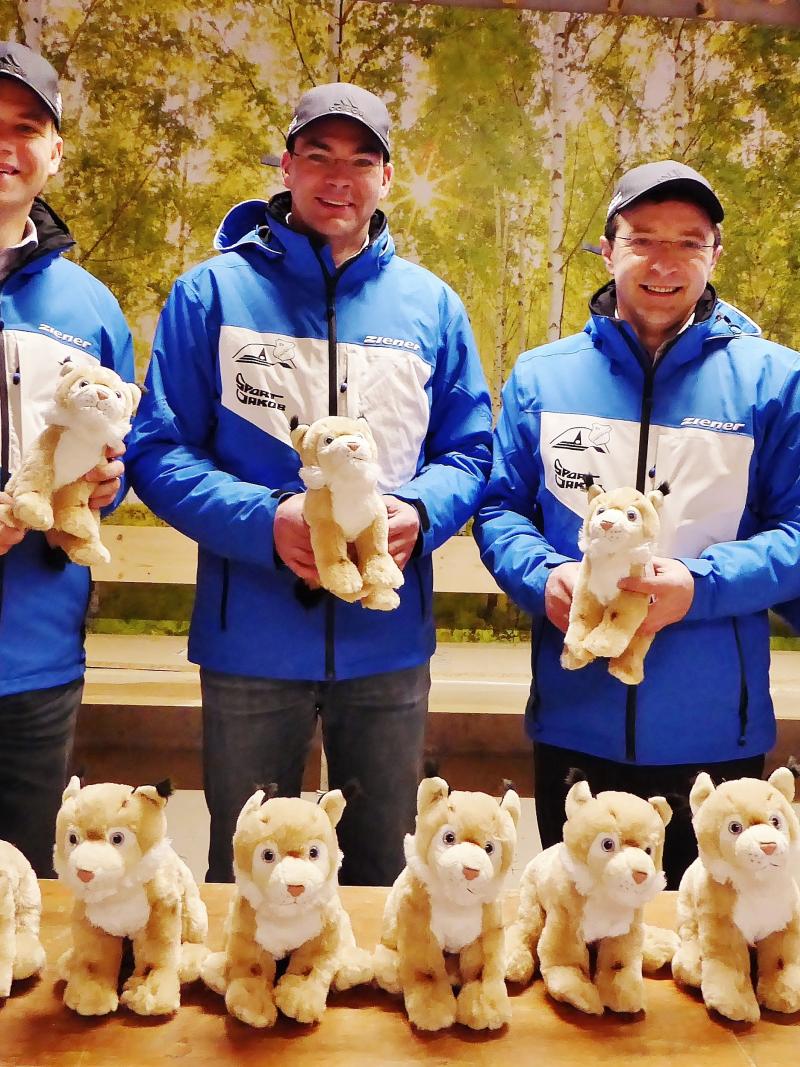 Four men in blue jackets show toys