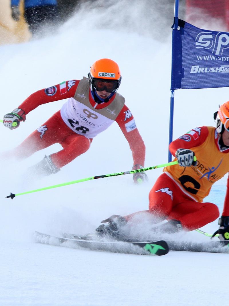 A Para alpine skier and guide make a turn round a gate.