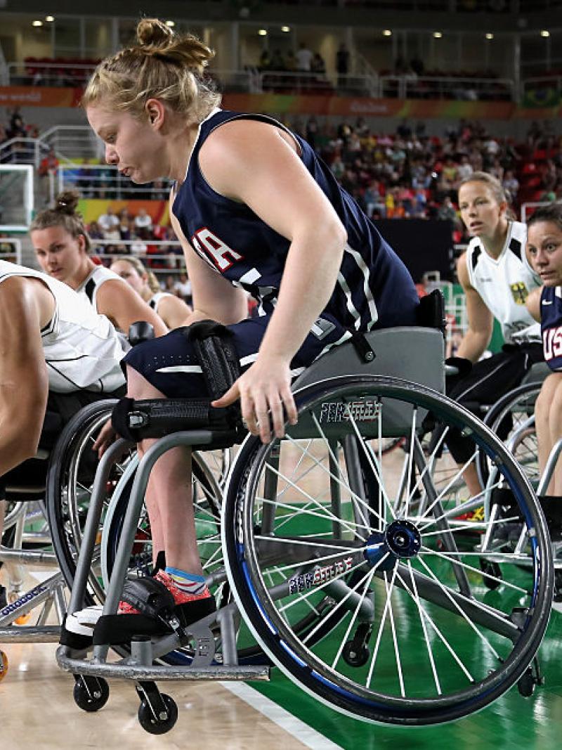 Two women in wheelchairs on the basketball court