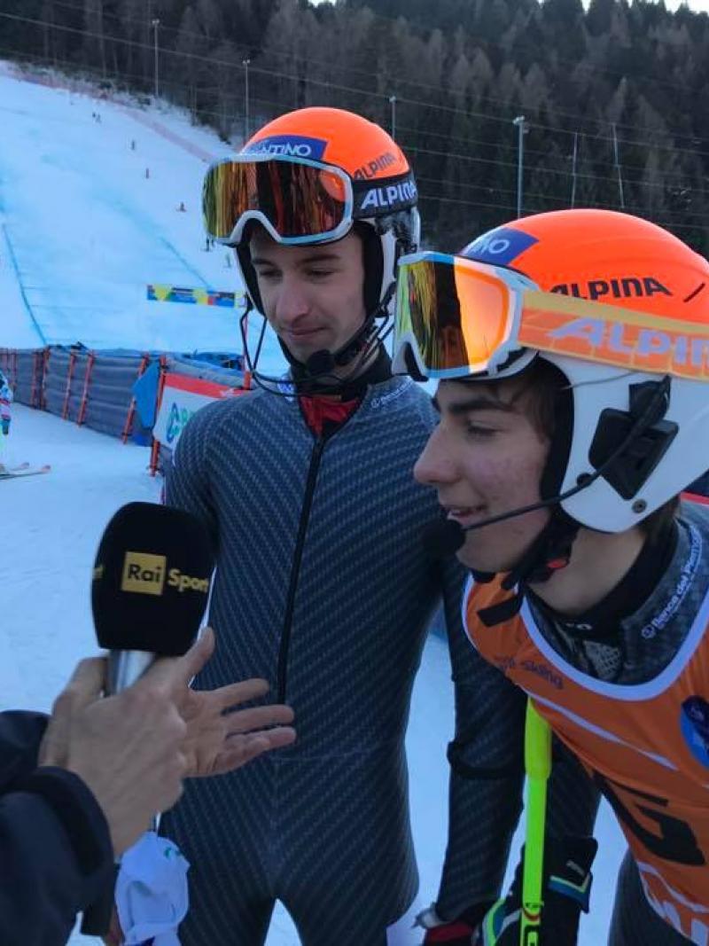 A visually impaired skier and his guide are interviewed