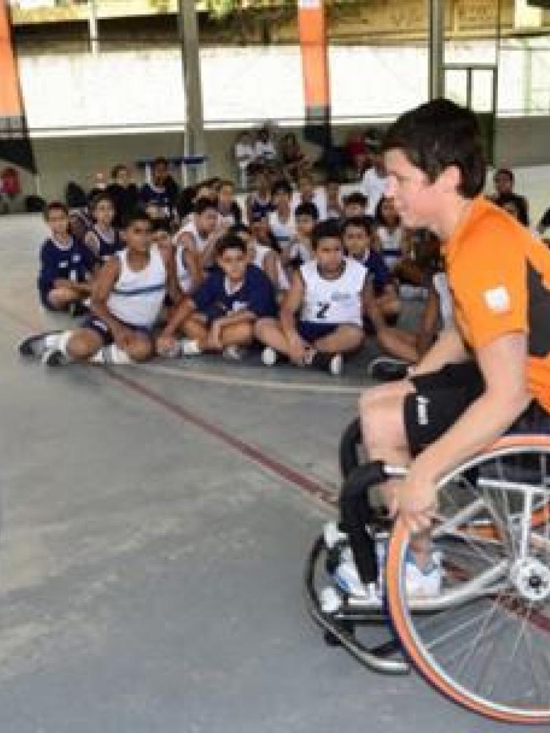 Inge Huitzing, sitting in a wheelchair and playing basketball, visits a school in Brazil