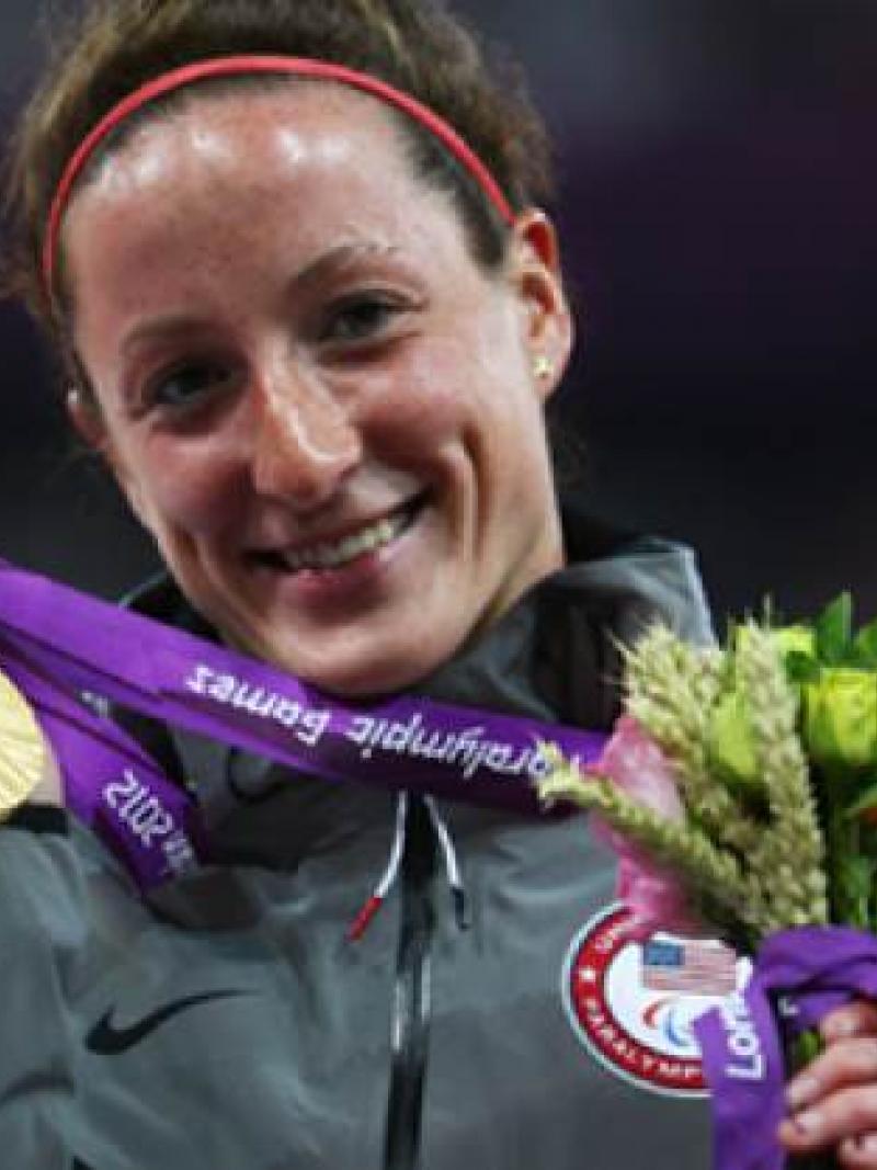 A picture of a woman showing her gold medal