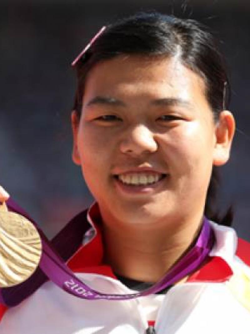 A picture of a chinese woman showing her gold medal