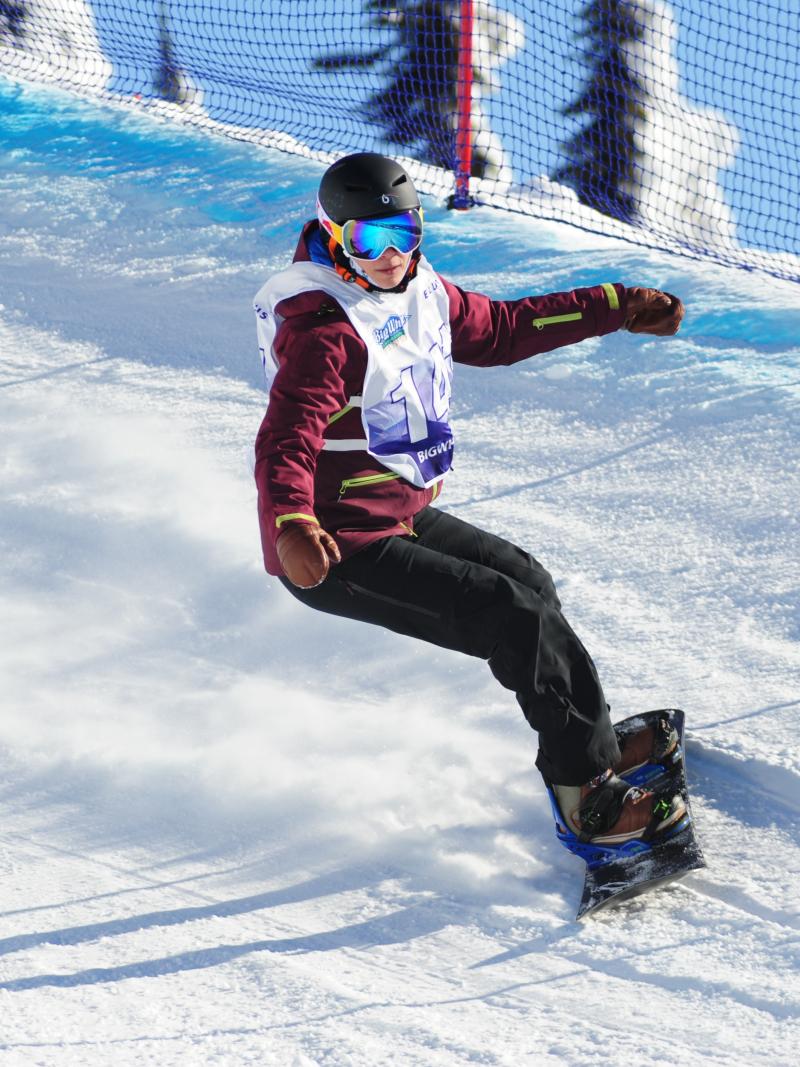 Woman on snowboard turns on a banked turn
