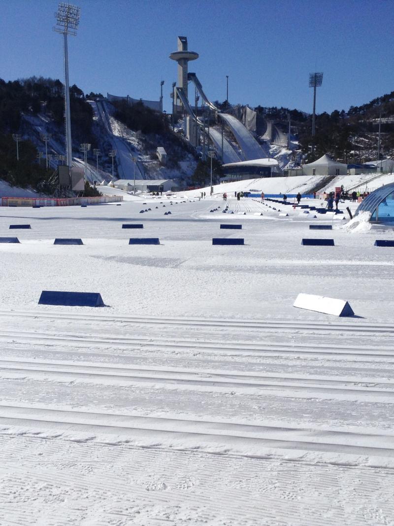 View on a snowy cross-country venue with a ski jump in the background