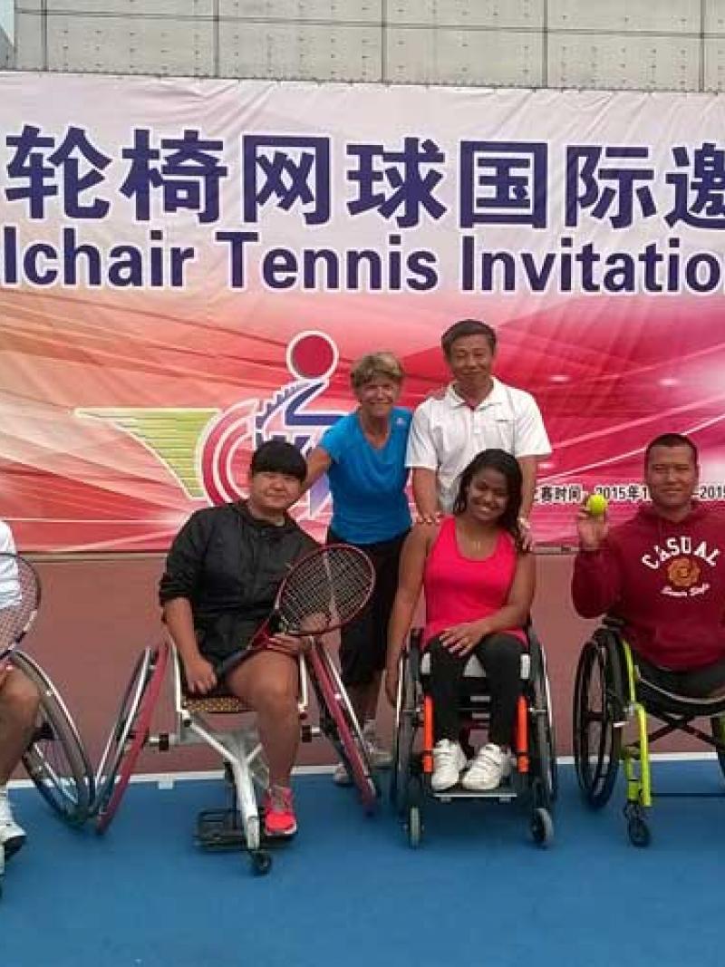 Group picture on a tennis court with some people in wheelchairs