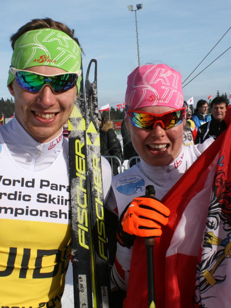 Two cross-country skiers with an Austrian flag
