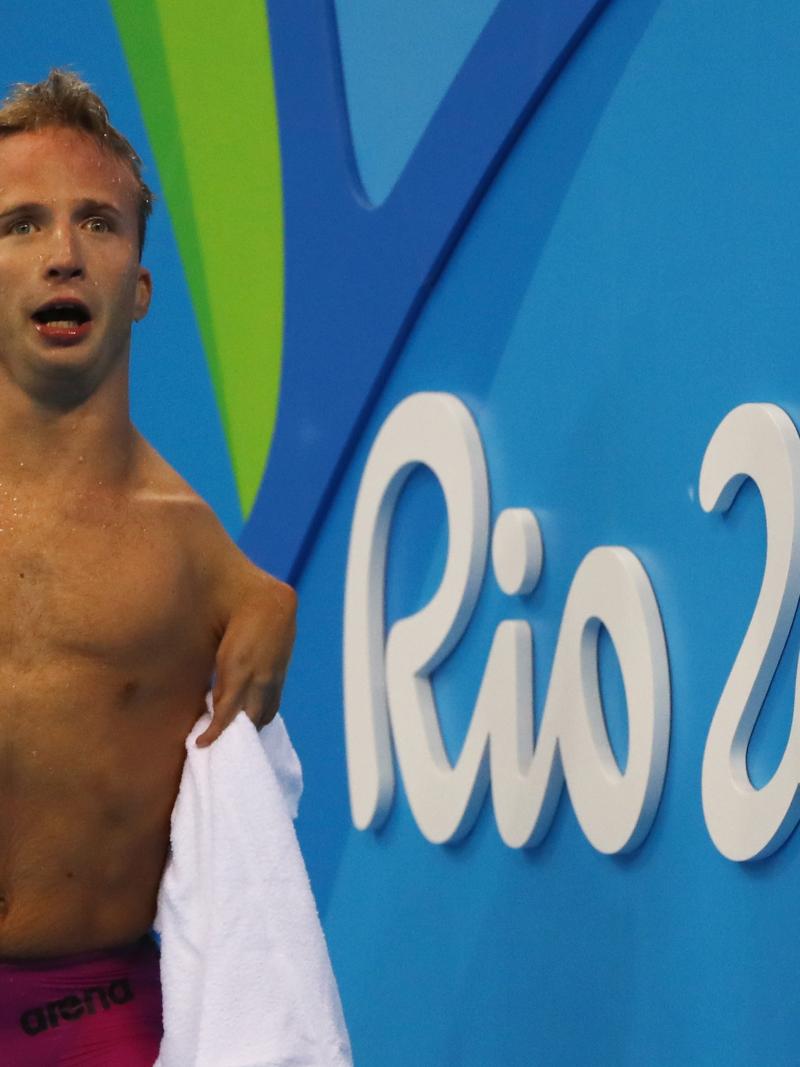 Male swimmer celebrates on pool deck