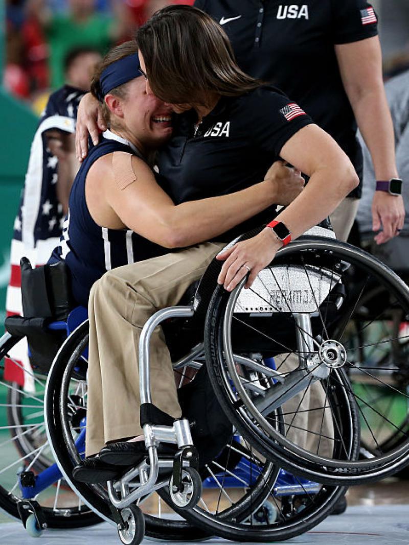 Two women in wheelchairs hugging each other