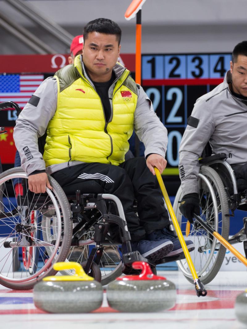 Chinese wheelchair curling players watching the stones