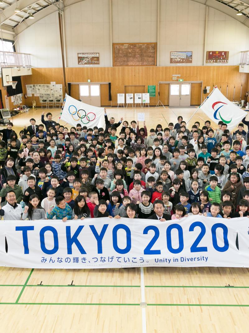 Group picture of many people gathering around a banner