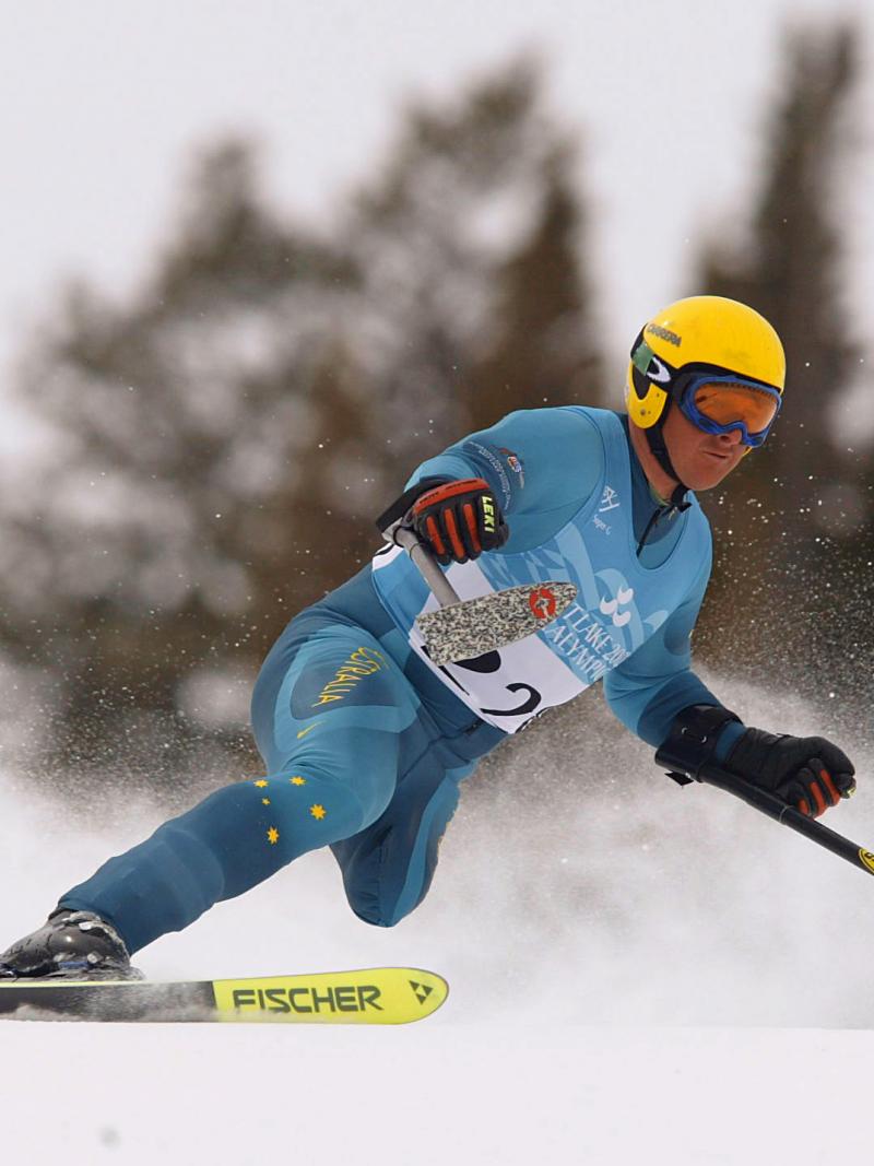 Man with one leg skis down a hill.