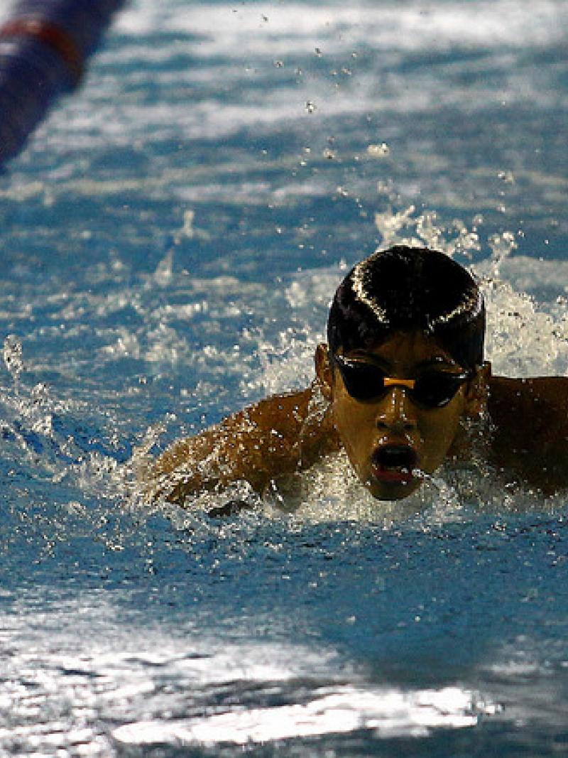 Boy with swim cap and goggles swims