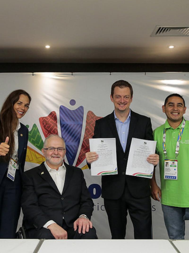 People pose for photo after a partnership agreement is signed