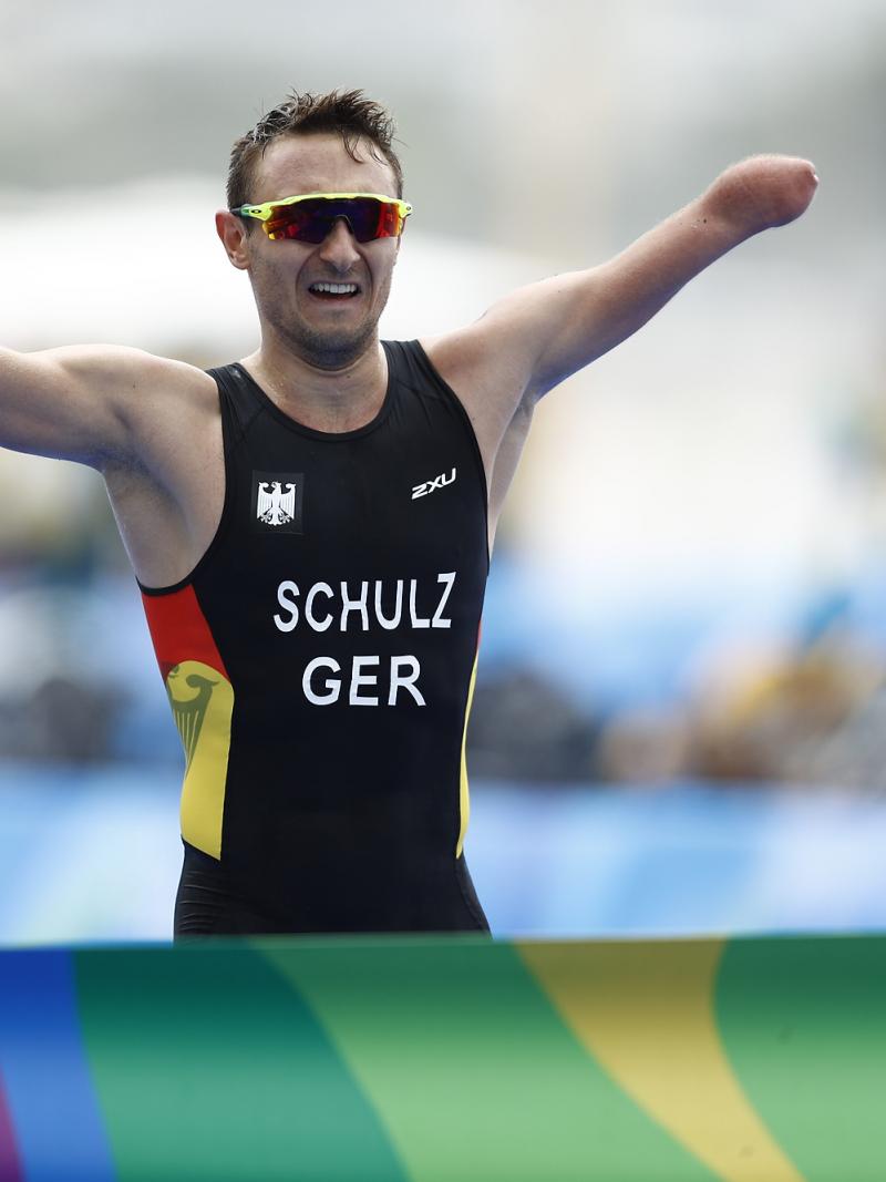Man with missing left forearm races arms as he is about to cross a finish line
