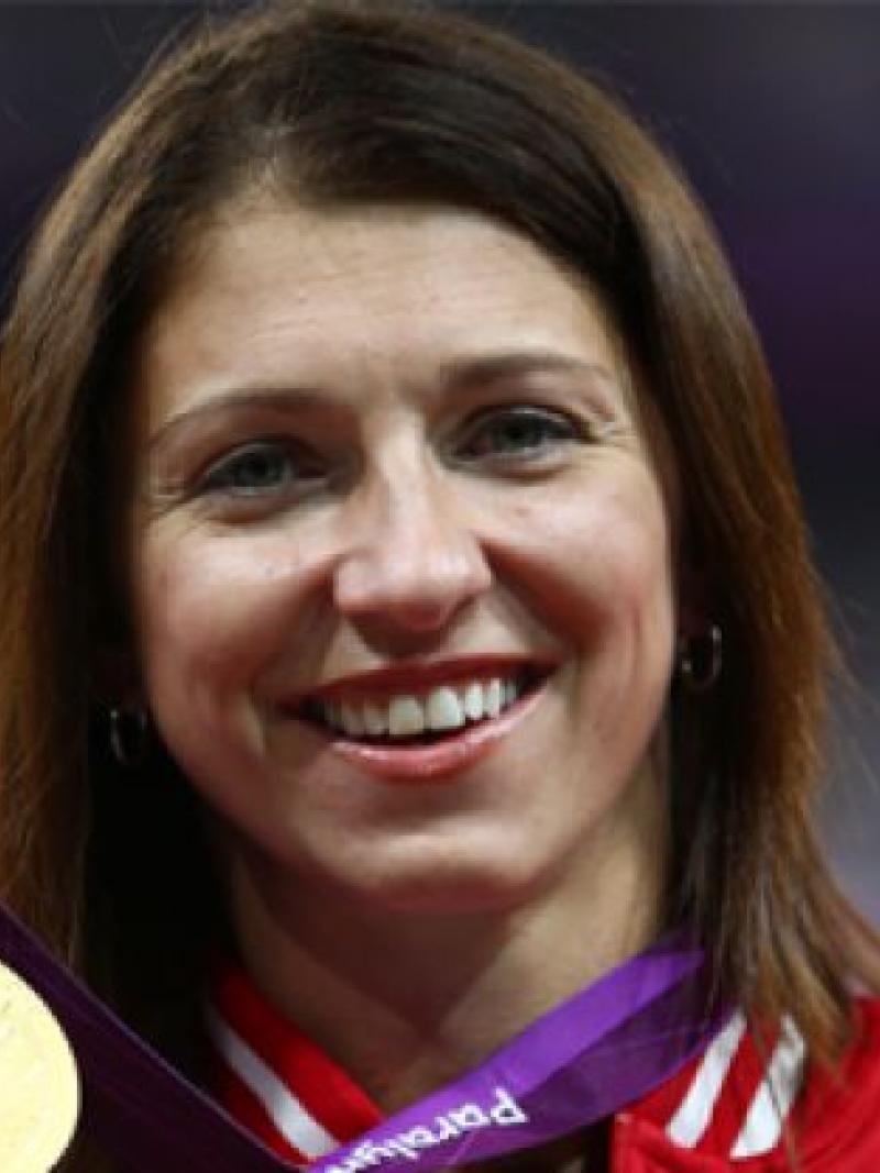 A picture of a woman showing her gold medal
