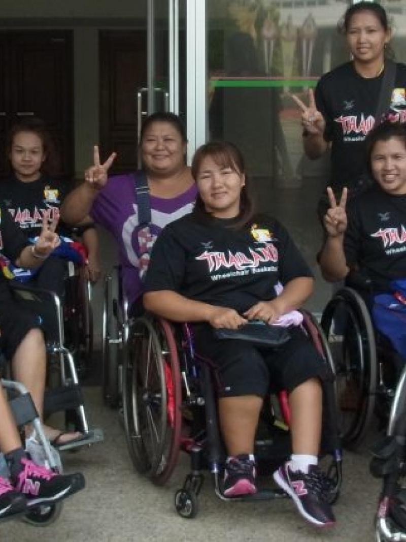 Group of Asian women's wheelchair basketball players pose 
