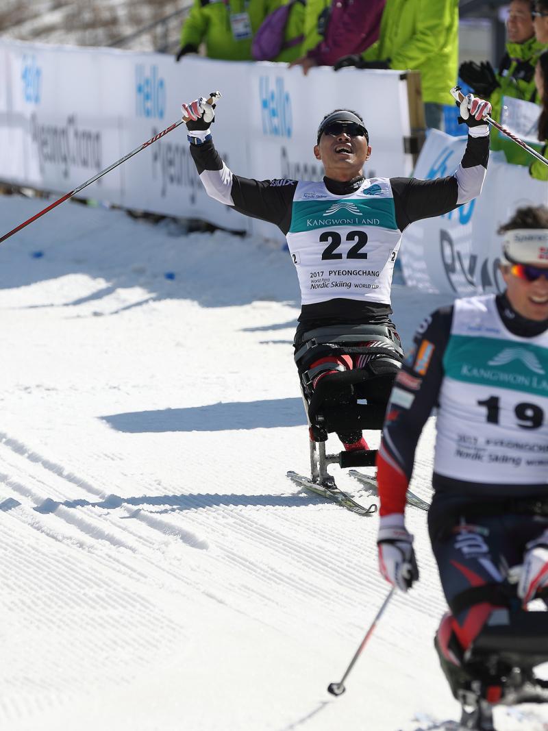 A sit skier celebrates his performance
