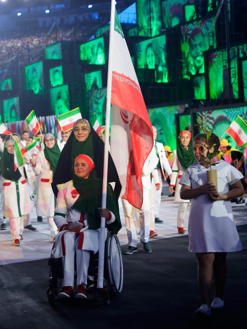 Woman in wheelchair carries Iranian flag during Opening Ceremony