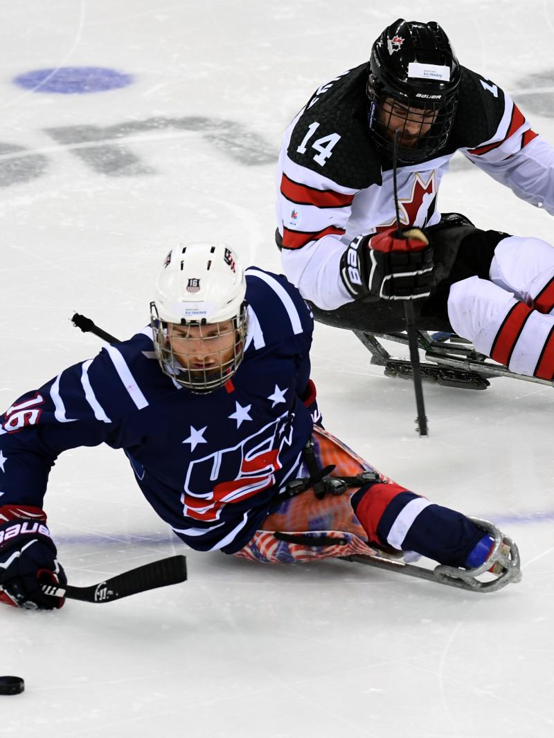 Man on ice hockey sledge makes a move with the puck