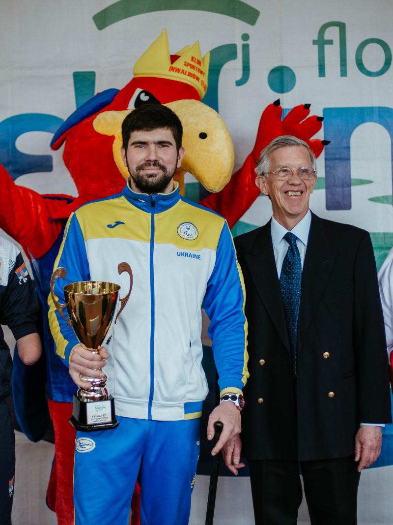 Three men holding trophies 