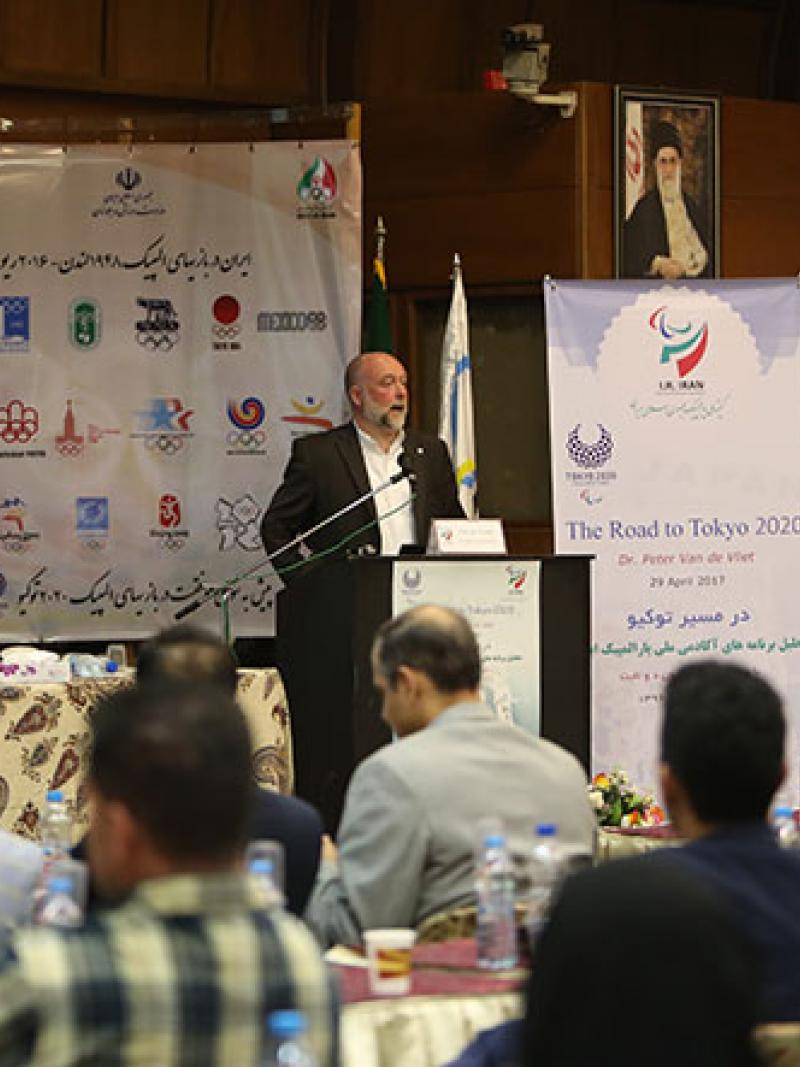 Man speaks to a crowd of people attending a seminar