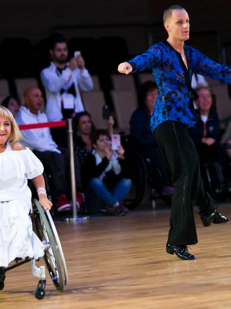 Woman in wheelchair dances with standing male partner 
