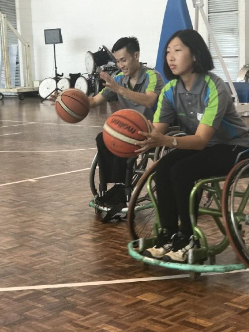 Woman in wheelchair shooting a basketball