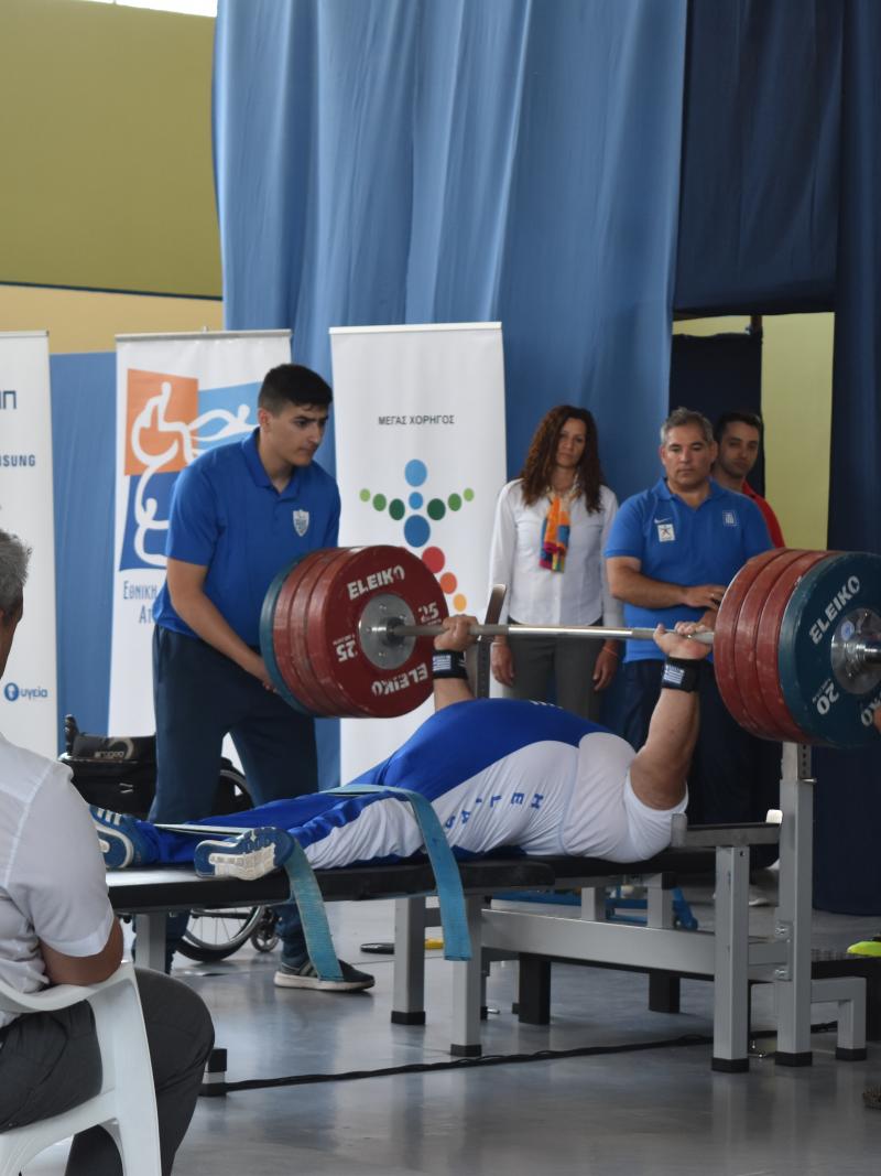 man powerlifting weights on bench