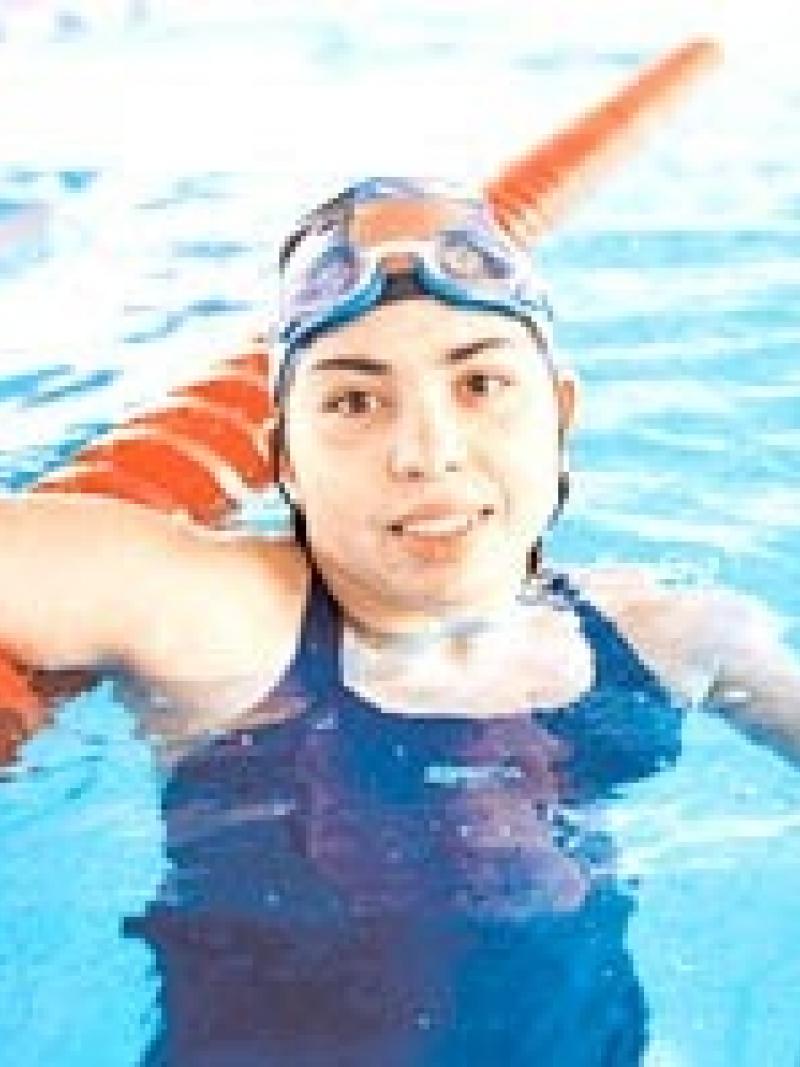 female swimmer celebrates in pool after winning race